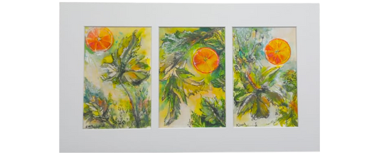 Framed triptych of three watercolour paintings showing orange slices floating among green leaves, set against a soft yellow background.