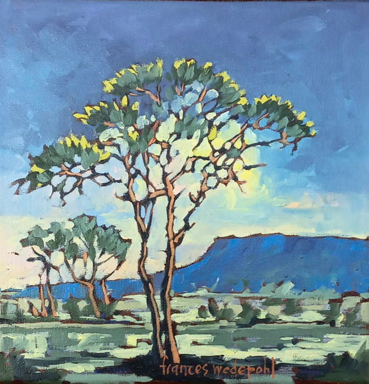 Oil painting of a tree with green and yellow leaves framing distant blue mountains under a soft blue sky.