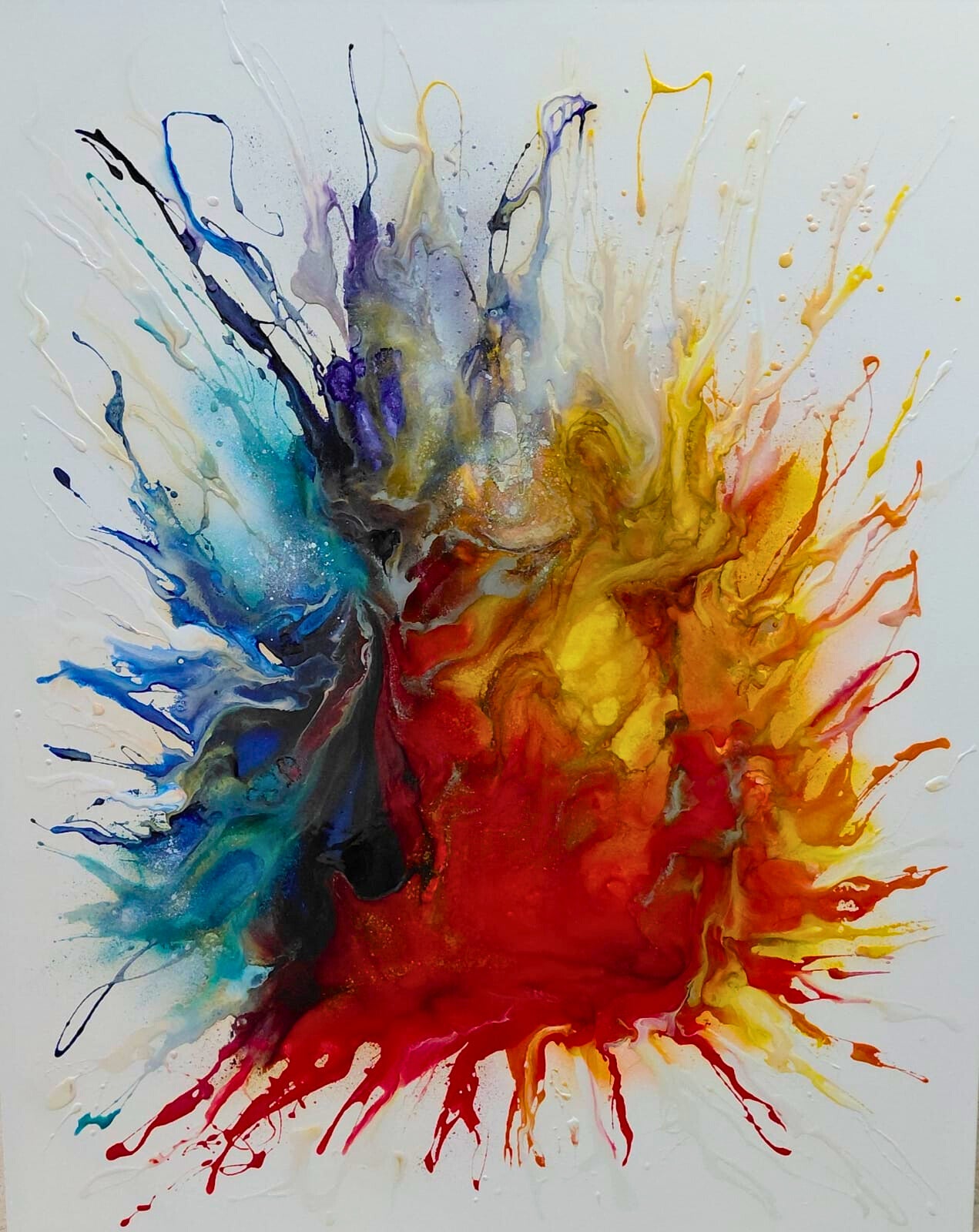 Mixed media abstract painting of a vibrant explosion of red, yellow, blue, and other colours splashing from the centre on a white background.