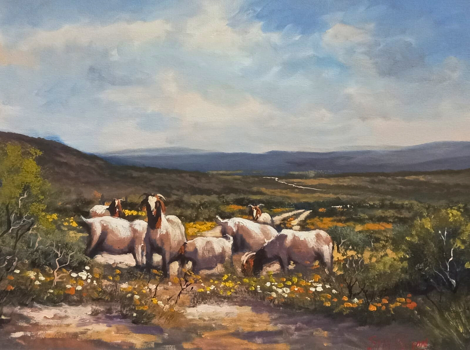 Oil painting of goats grazing among wildflowers on a sunlit hillside, with distant mountains and a winding road under a soft blue sky.