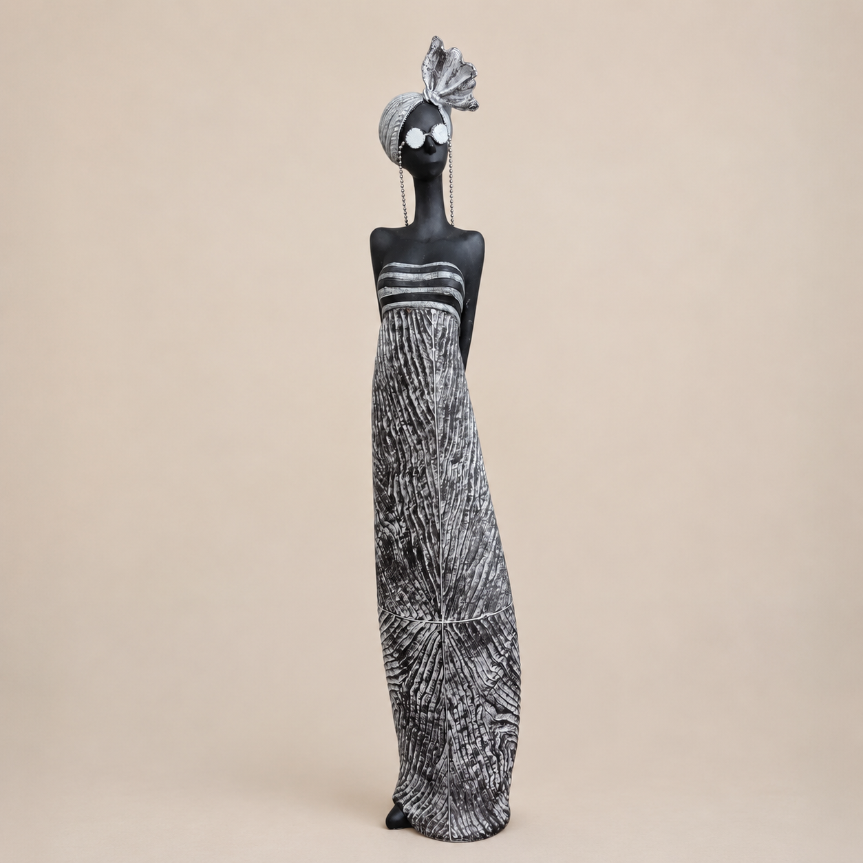 Black and Silver Standing Lady Sculpture photographed on a warm beige studio background