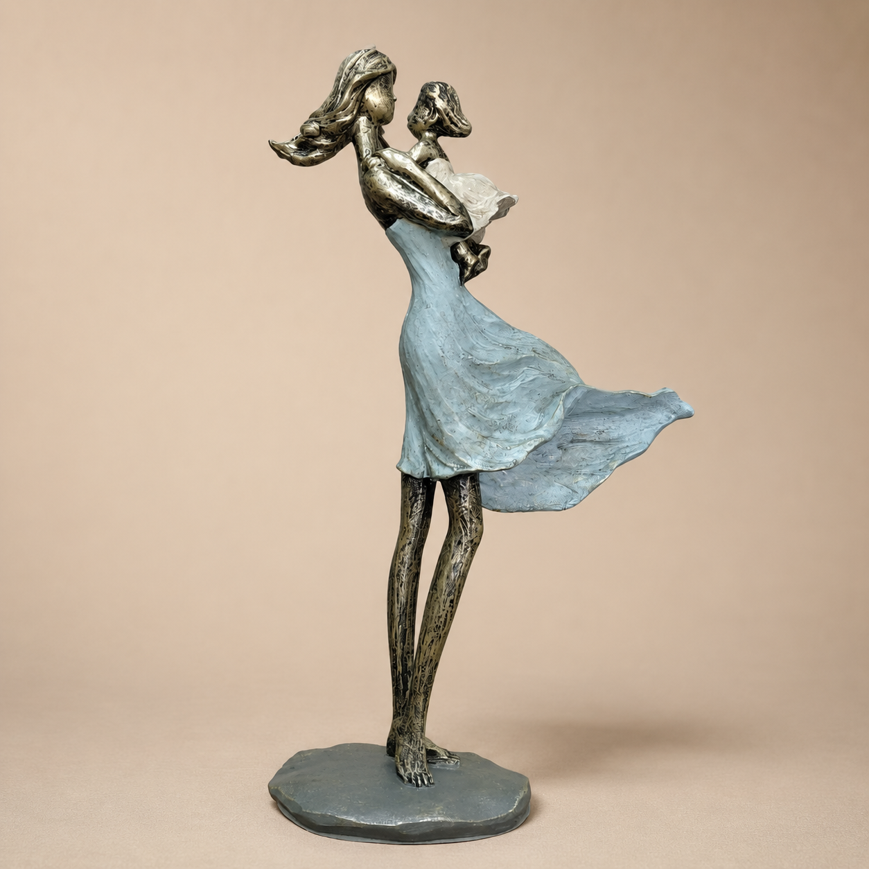 Blue Mother and Child Standing Sculpture photographed on a warm beige studio background