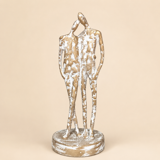 Distressed Gold Standing Couple Figurine photographed on a warm beige studio background