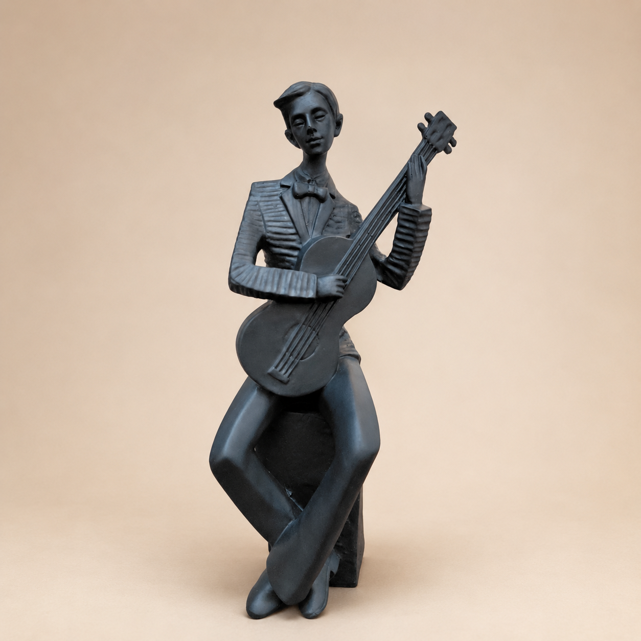 Seated Guitarist Musician Sculpture photographed on a warm beige studio background