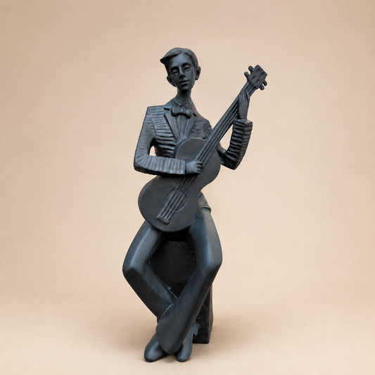 Seated Guitarist Musician Sculpture photographed on a warm beige studio background