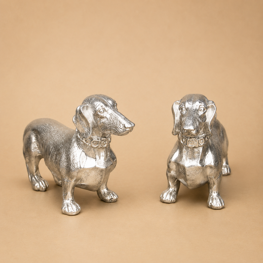 Silver Dachshund Figurines – Pair photographed on a warm beige studio background